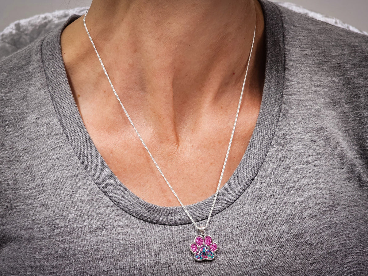 pawprint opal pendant with cremation ash worn by woman

